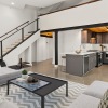 open concept living room and kitchen with stairway to loft